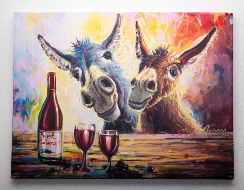 Two donkeys with wine glasses and a bottle