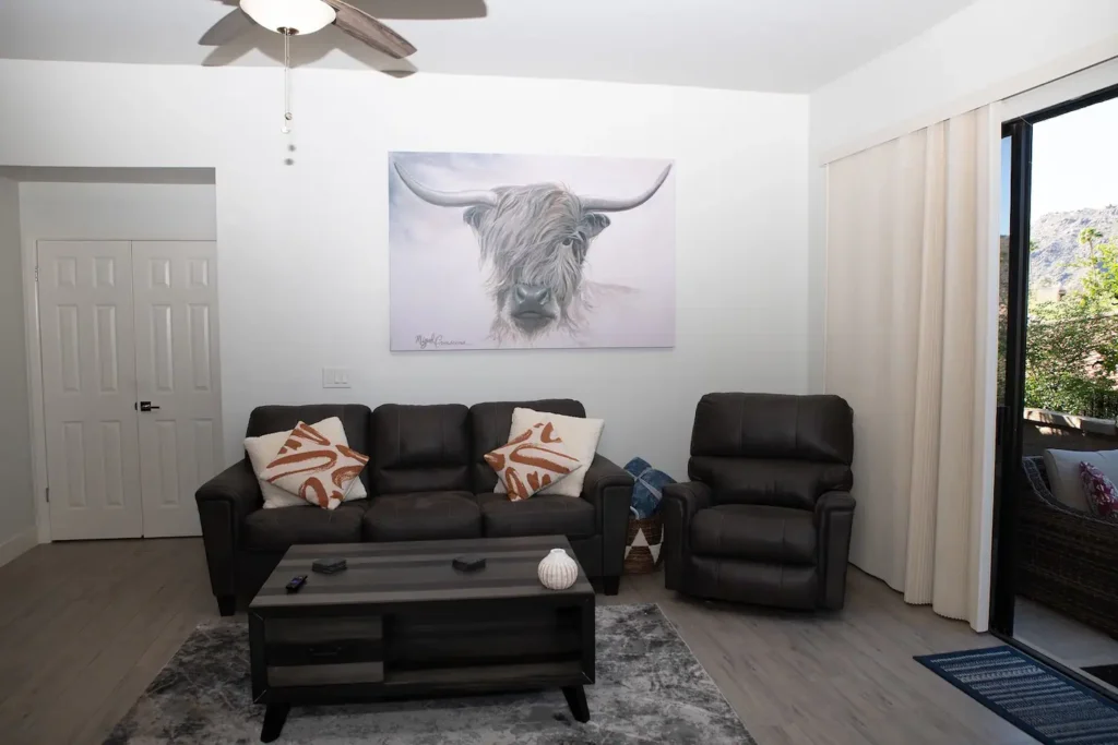 A living room with a couch, chair and table.