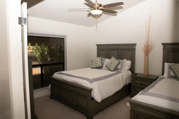 A bedroom with a bed, dresser and window.