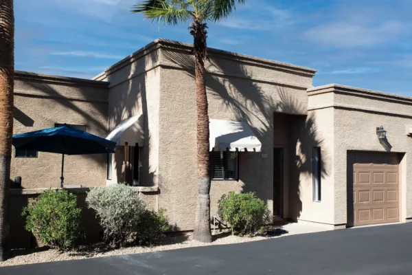 A building with a palm tree in front of it.