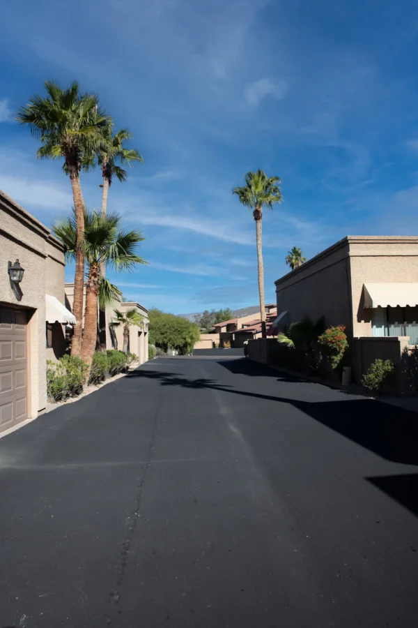 A street with palm trees and buildings on the side.