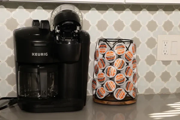 A coffee maker and cup holder on the counter.