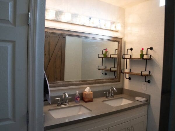 A bathroom with two sinks and a large mirror.