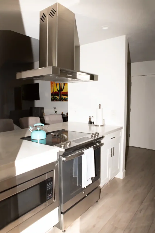 A kitchen with stainless steel appliances and white counters.