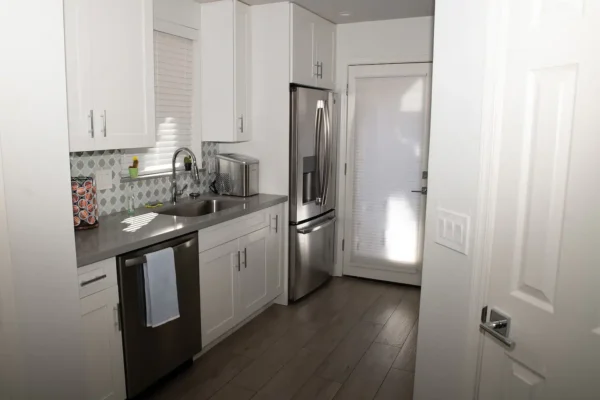 A kitchen with white cabinets and stainless steel appliances.