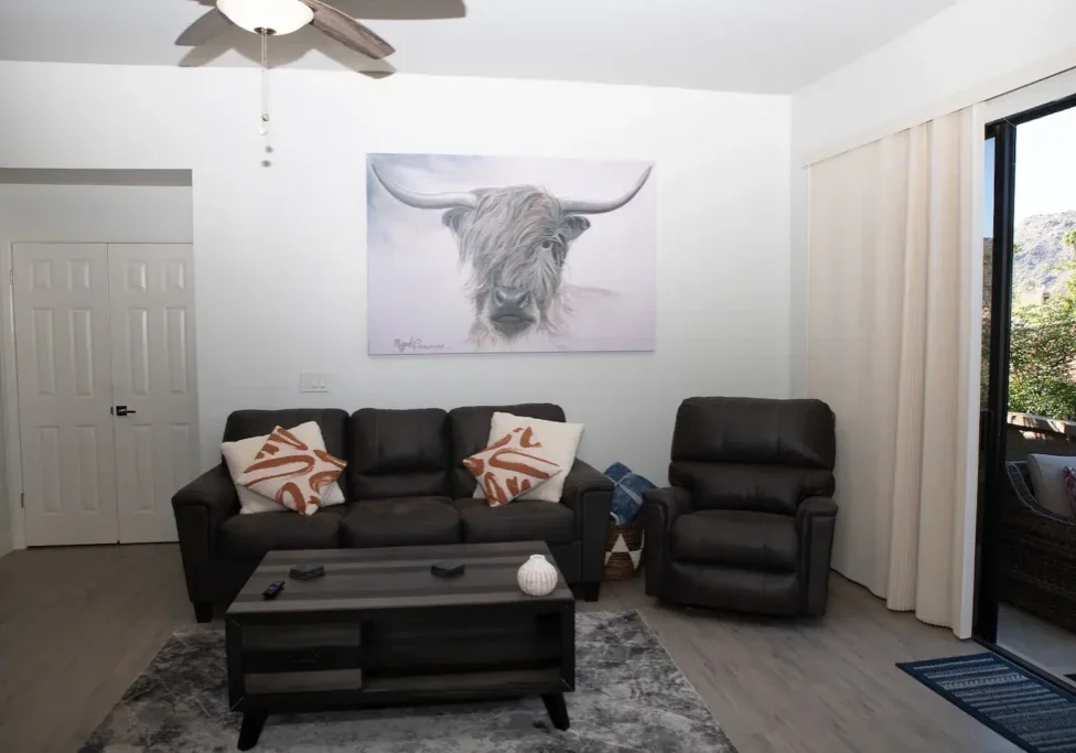 A living room with a couch, chair and table.